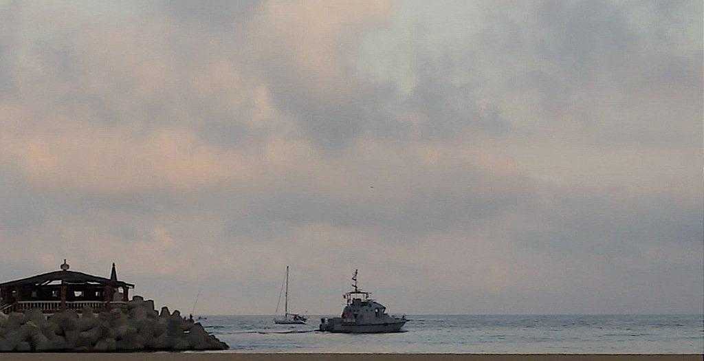 boat escorted out by marine ship.jpg