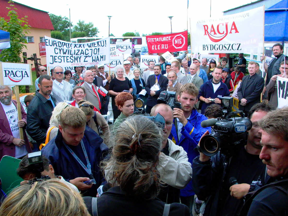 Facing press and protesters